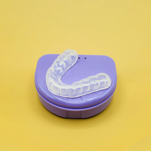Custom mouth guard for teeth grinding on a purple case.
