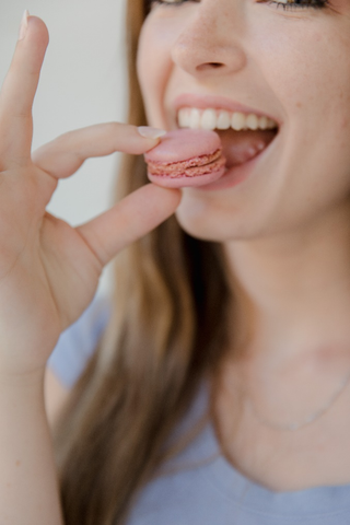 a woman eating a macaron