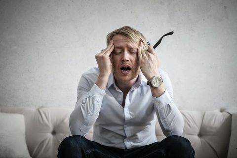 A person holding their head due to a headache