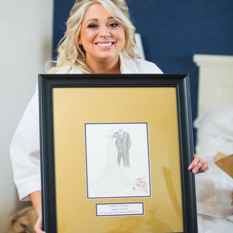 Bride holding a sketch of her wedding dress on her wedding day.