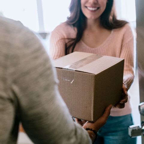 A woman receiving a package at her door