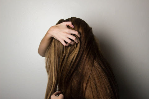 a woman having her face covered with her hair. (Nagarmotha helps in treating hair problems)