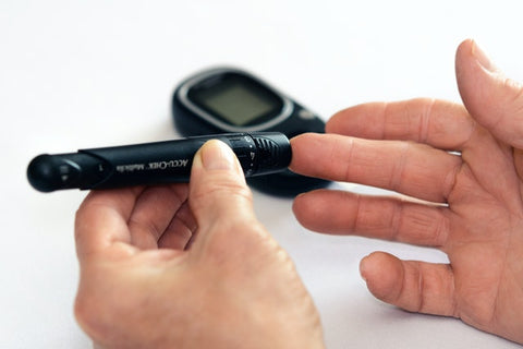benefits of ashwagandha powder - a person checking blood sugar with accucheck