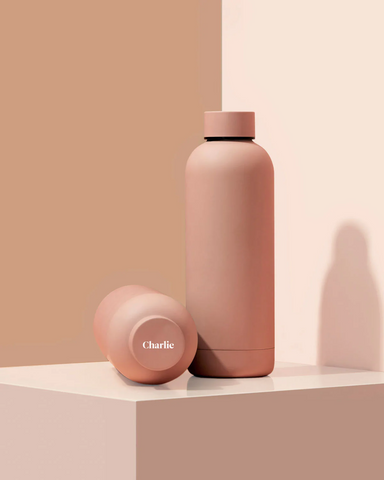 personalized soft pastel pinkish colored, Stainless steelwater bottle with the name "Charlie" on top of the lid