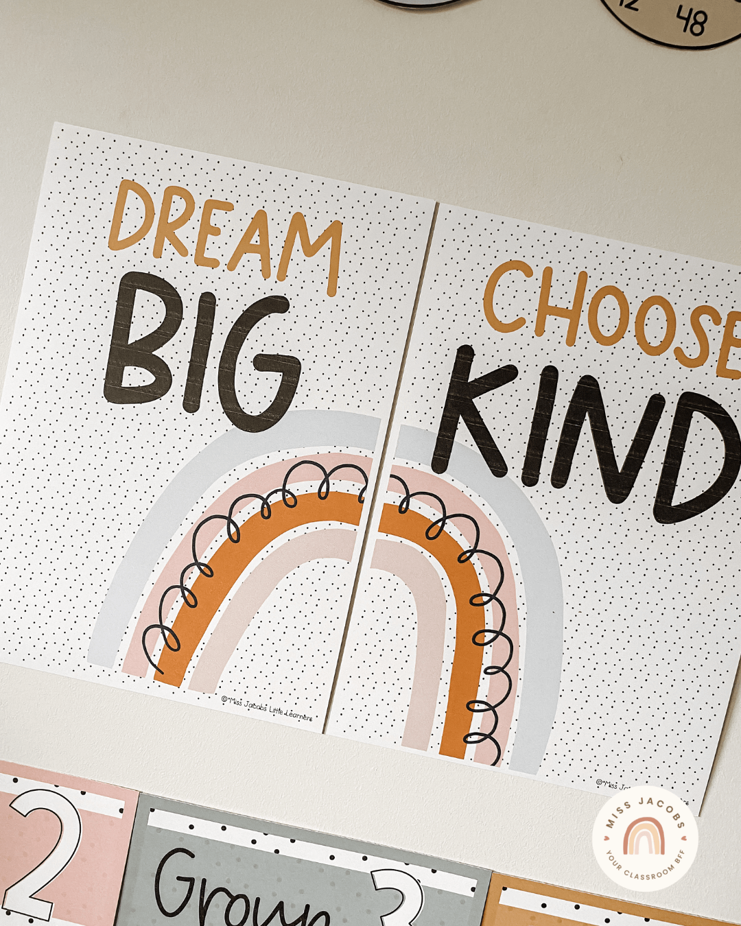 The left image shows an overhead shot of two clipboards with a plant and stationery. The clipboards feature ‘Amazing Work Coming Soon’ posters from the Boho Vibes range. The right image shows two motivational posters with the words ‘Dream Big’ and ‘Choose Kind’ from the Spotty Boho range.