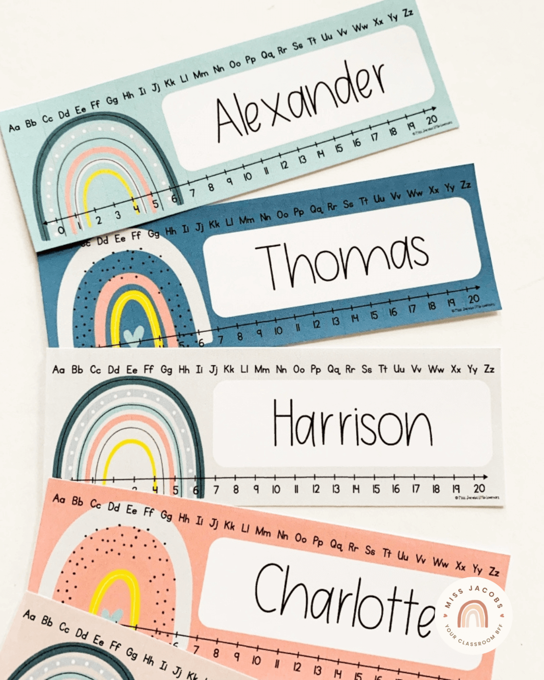 The left image shows a door display from the Modern Rainbow range. The central poster says ‘We are a rainbow of possibilities with circular name labels surrounding it. They feature decorative rainbow illustrations in muted rainbow colours. On the right, name labels from the same range feature the names Alexander, Thomas, Harrison and Charlotte. They’re in mint, navy, grey and peach colourways.