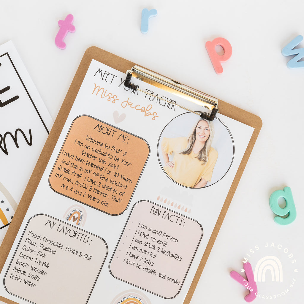 A printed ‘Meet the Teacher’ template is clipped to a brown clipboard. Colourful letter magnets are scattered around it.