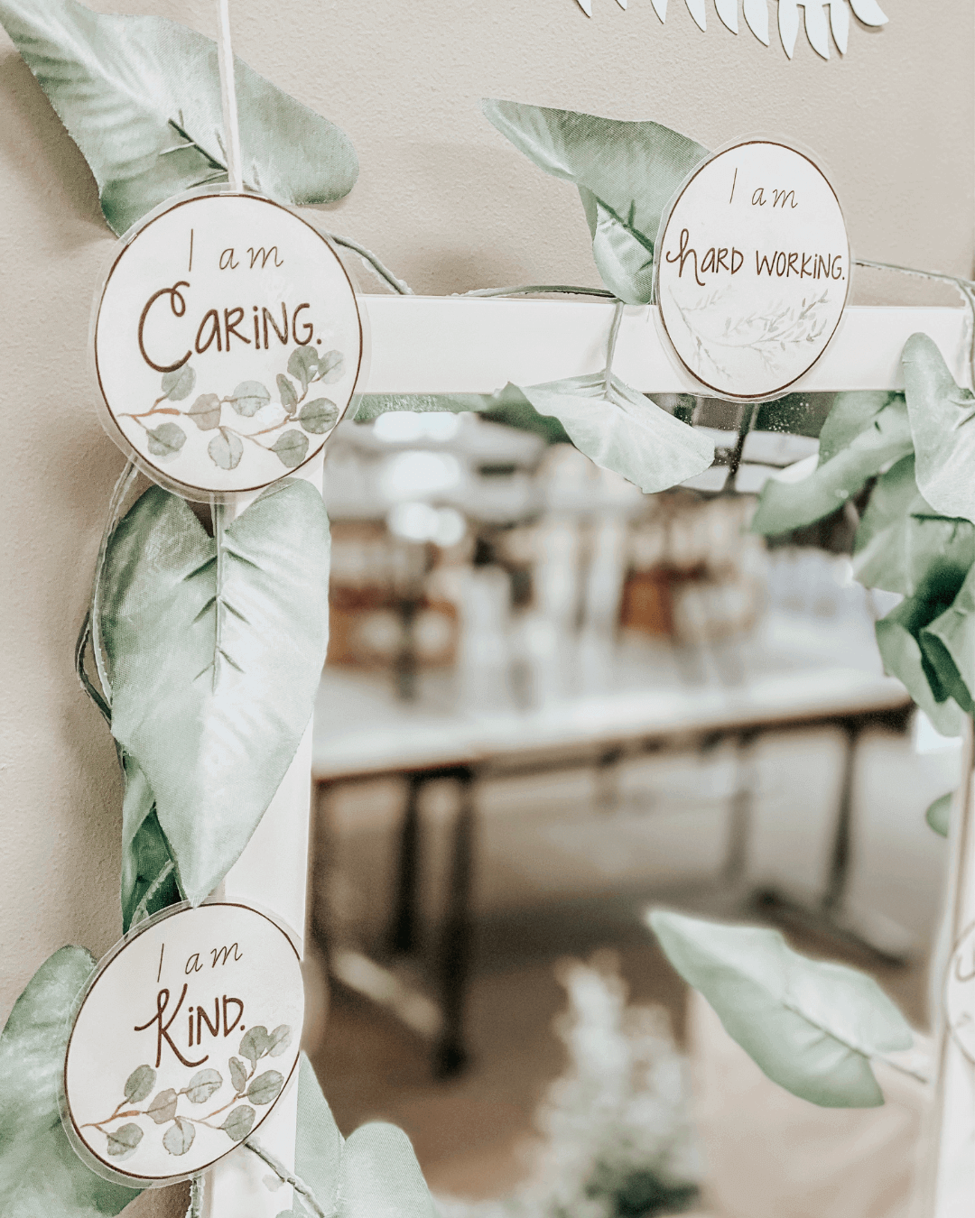 Three images show Botanical classroom displays bordering long mirrors. The displays include a number of motivational phrases and the mirror on the right is framed by a garland of faux leaves.” style=