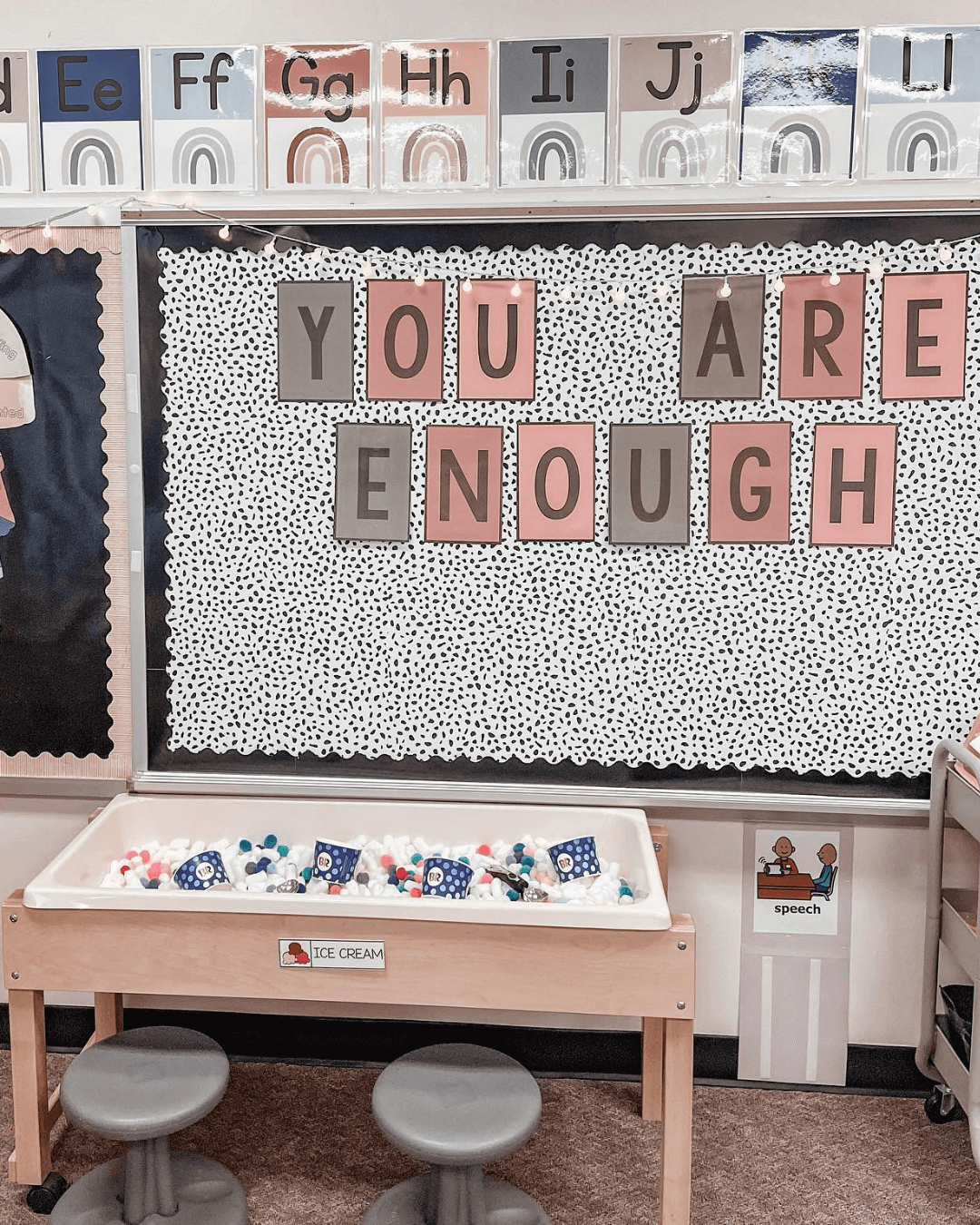 The left image shows a series of items from the classroom jobs resource, it includes small cutouts with jobs like ‘librarian’ and ‘recess helper.’ The right image shows a wall display that says ‘you are enough’ from the neutral Boho Rainbow Lettering Pack.