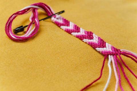 a pink woven friendship bracelet