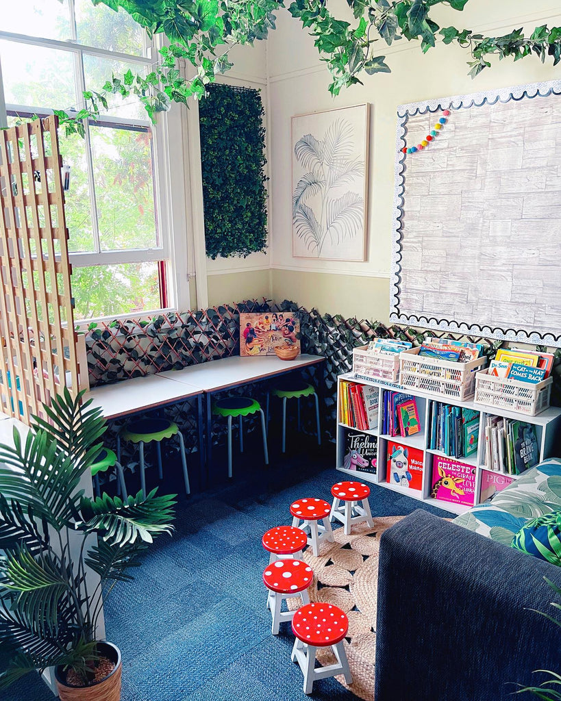 Two images show a brightly coloured ‘Investigation Table’ zone, where a line of tables sit below a large caterpillar decal. The next image shows a number of toadstool stools, with a bookshelf, a bench and ivy draped around the room.