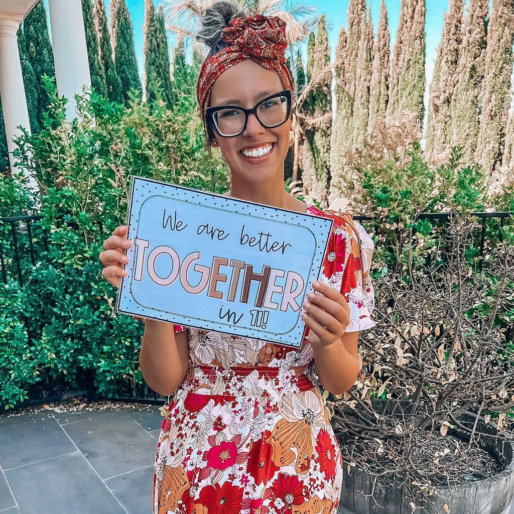 @teachingwithmissamanda is dressed in a bright floral outfit holding up a beautiful Spotty Neutral Sign from Miss Jacobs Little Learners that reads 'we are better together in Il