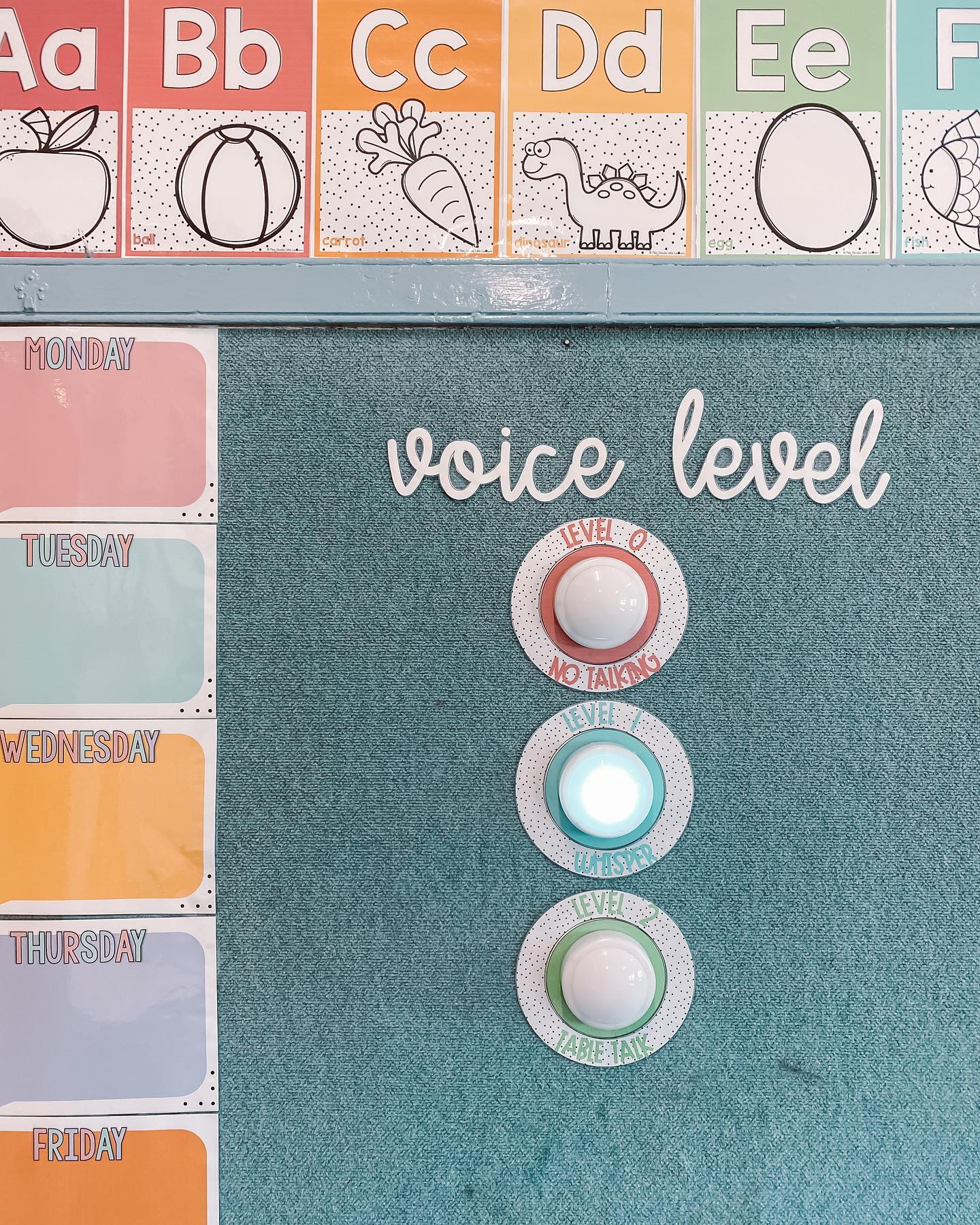 Two images show an earthy rainbow Hand Signal display on the classroom wall, and the second image is of a spotty brights rainbow voice level lights display