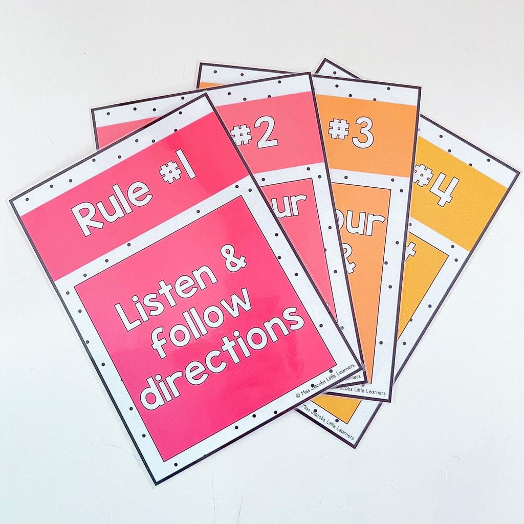 Colourful sheets of paper are labelled with class rules. The first reads “Rule 1 - listen and follow directions.”