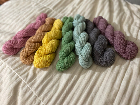 A rainbow of naturally dyed sock yarn displayed in a roygbiv color set