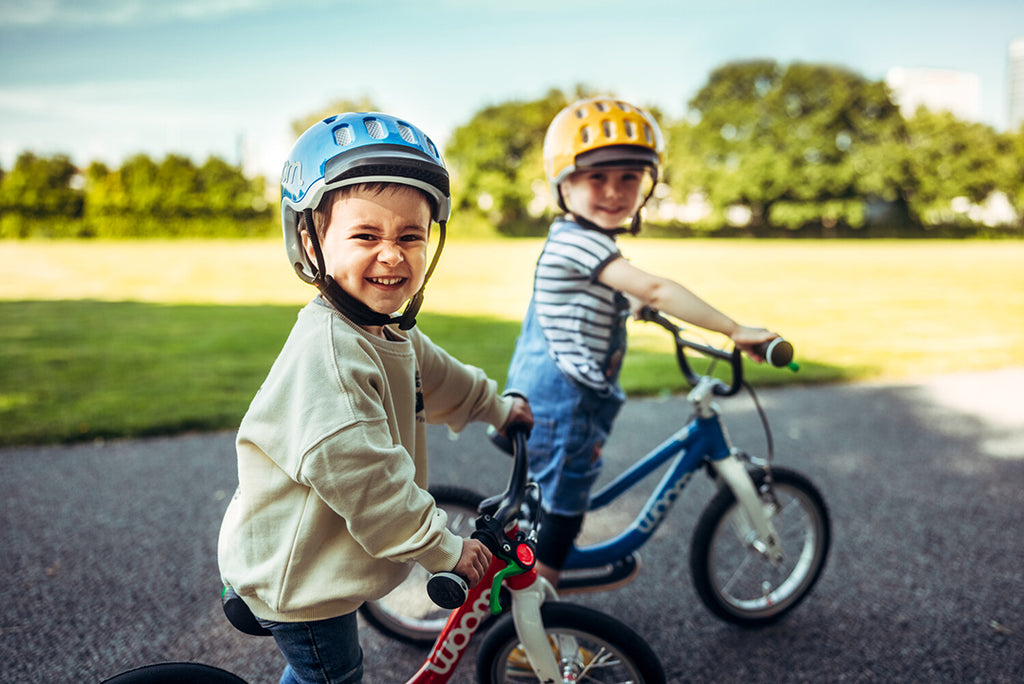 Zwei kinder fahren auf ihren Laufrädern