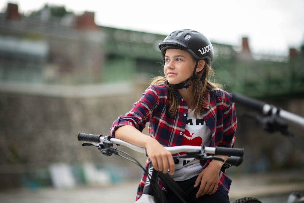 Mädchen lehnt am Lenker ihres Woom Mountainbikes