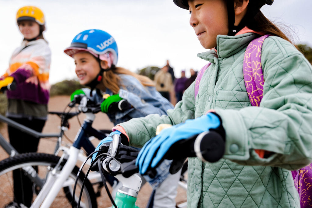 Kinder stehen mit ihren Crossbikes von Woom an einer Klippe