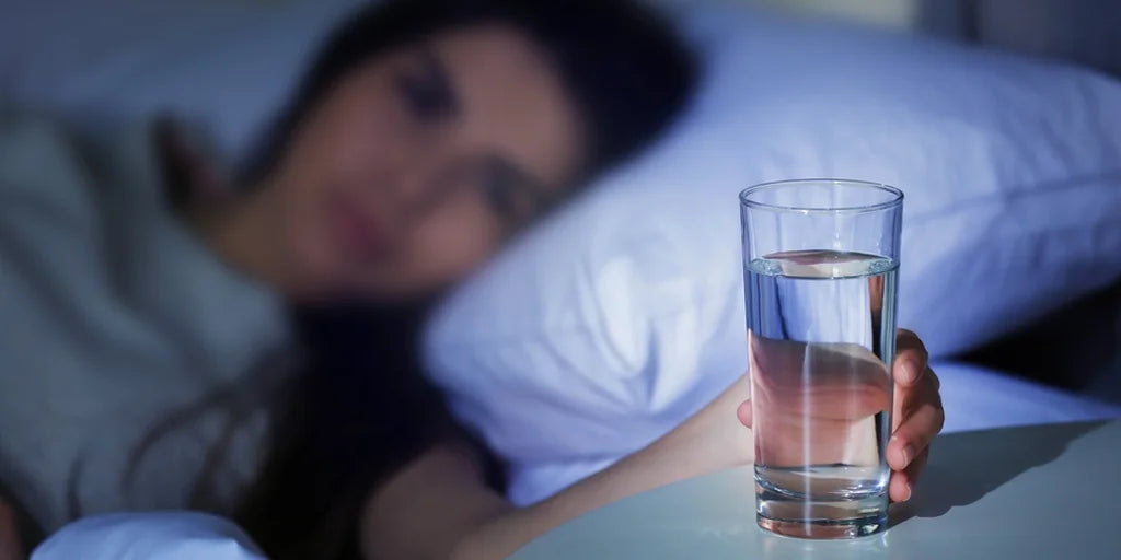 Why does staying up late influence daily water intake?