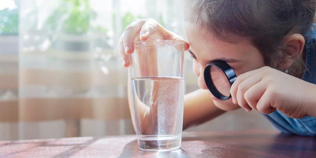 Kid-using- magnifying-glass-to-see-impurities-in -water