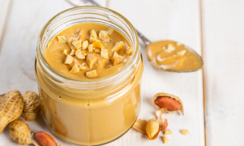 Peanut butter in a jar and on a spoon