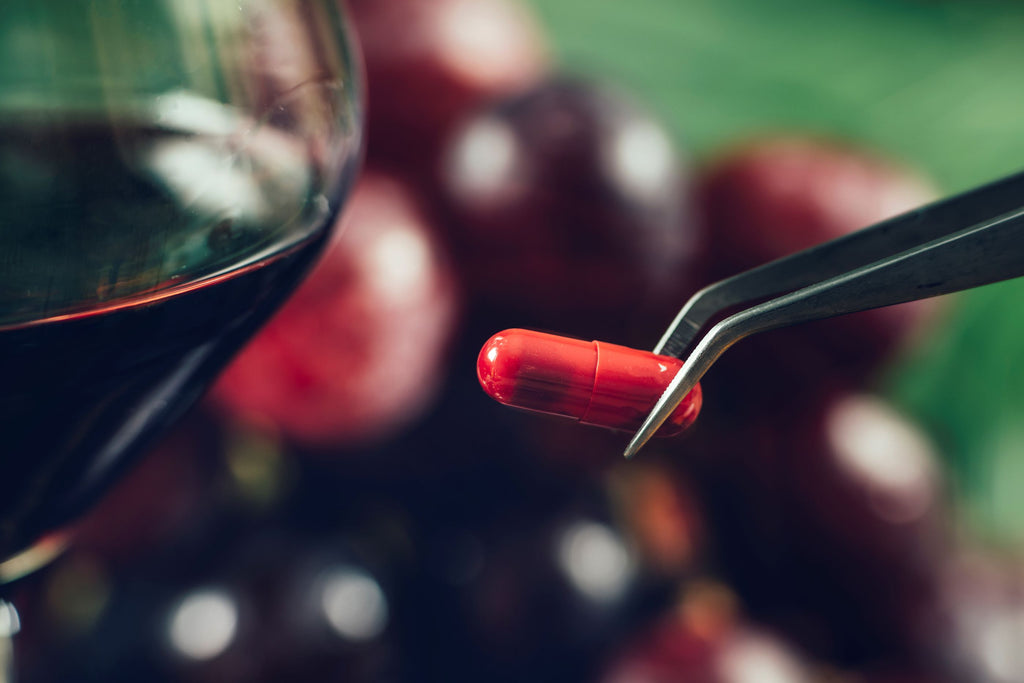 resveratrol supplement with grapes and red wine in the background