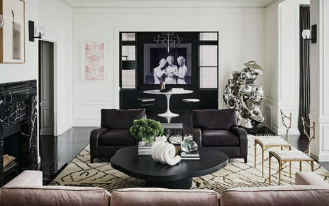 Black furniture with a black wooden table next to ablack marble fireplace.