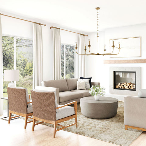 Light coffee colored furniture in a white room with a brass chandelier.