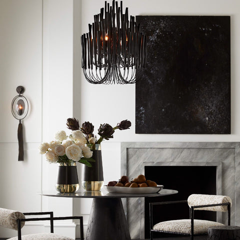 A black chandelier over a black glass table.