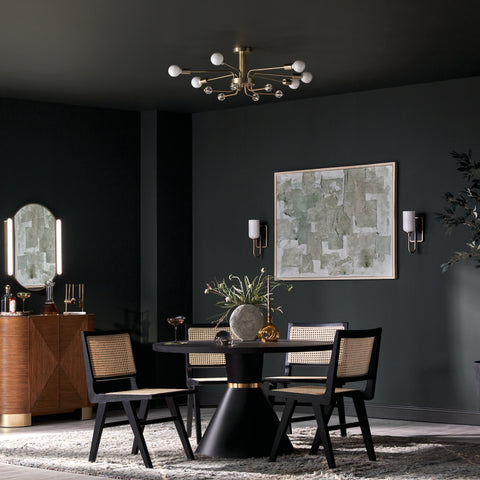 Kichler Ocala Chandelier hanging in a dining room with black walls and natural rattan dining chairs around a circular table