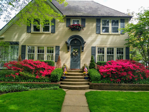 Tan house exterior with pink flowers