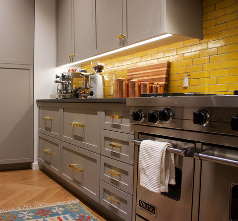 Undercabinet lighting in a kitchen with yellow backsplash