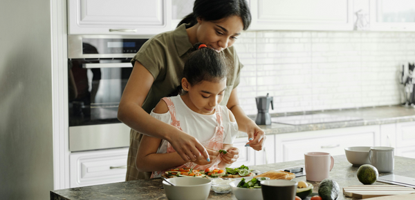 A mother and daughter preparing a salad together