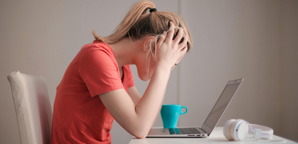 A stressed teenage girl on a laptop