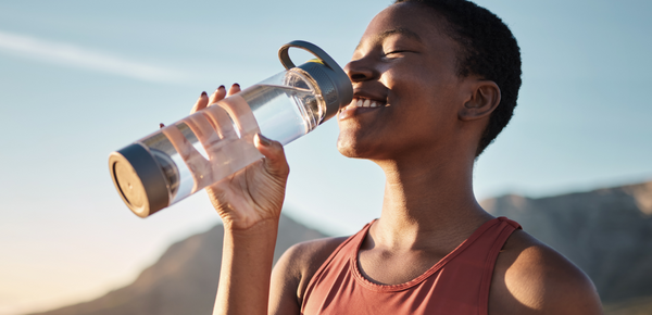 A woman drinking water after working out