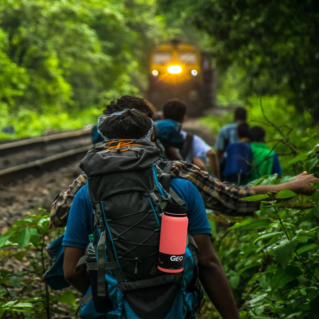 a group of hikers walking alongside a train track