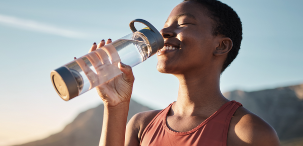 A woman outdoors enjoying a bottle of fresh filtered water