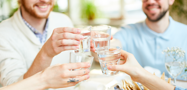 A group of friends toasting with glasses of a water