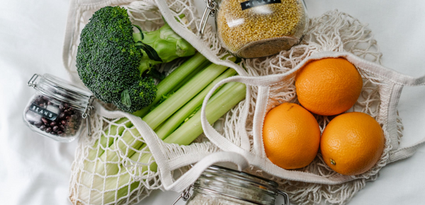 Fruit in reusable mesh bags and jars full of dried goods