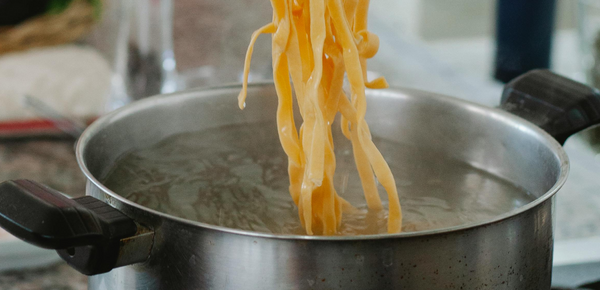 Noodles being cooked in a pot of boiling filtered water