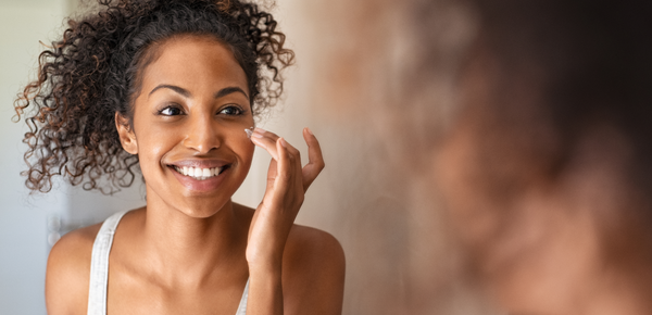 A woman admiring her glowing skin in the mirror