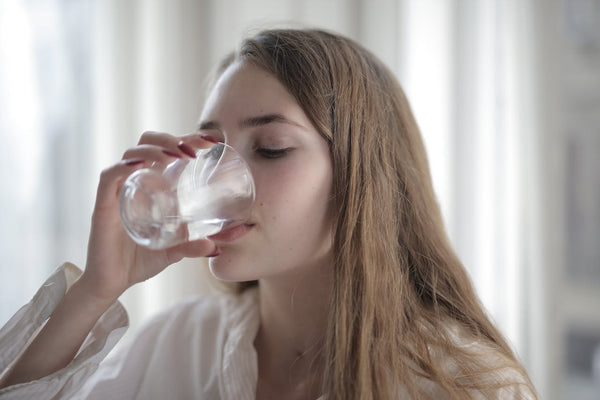 mujer bebiendo un vaso de agua