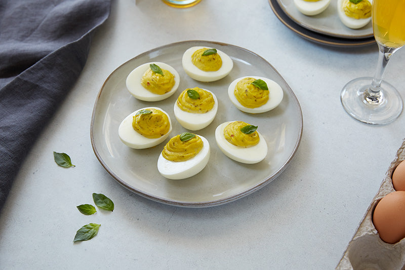 Pesto deviled eggs on a grey stone plate