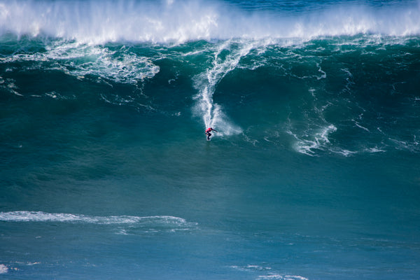 Surfer on a huge wave in Nazare Portugal