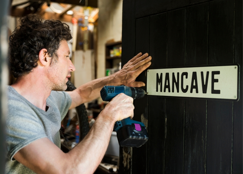 Guy putting up The Mancave sign 