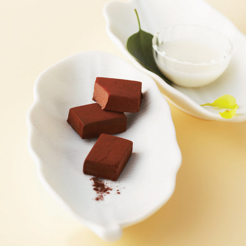 ROYCE' Chocolate - Image shows a picture of chocolate blocks on a white plate with a green leaf.