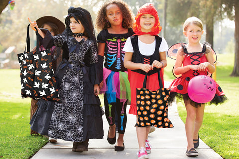 girls walking on sidewalk wearing halloween costumes