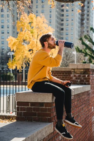 Man drinking out of a reusable bottle