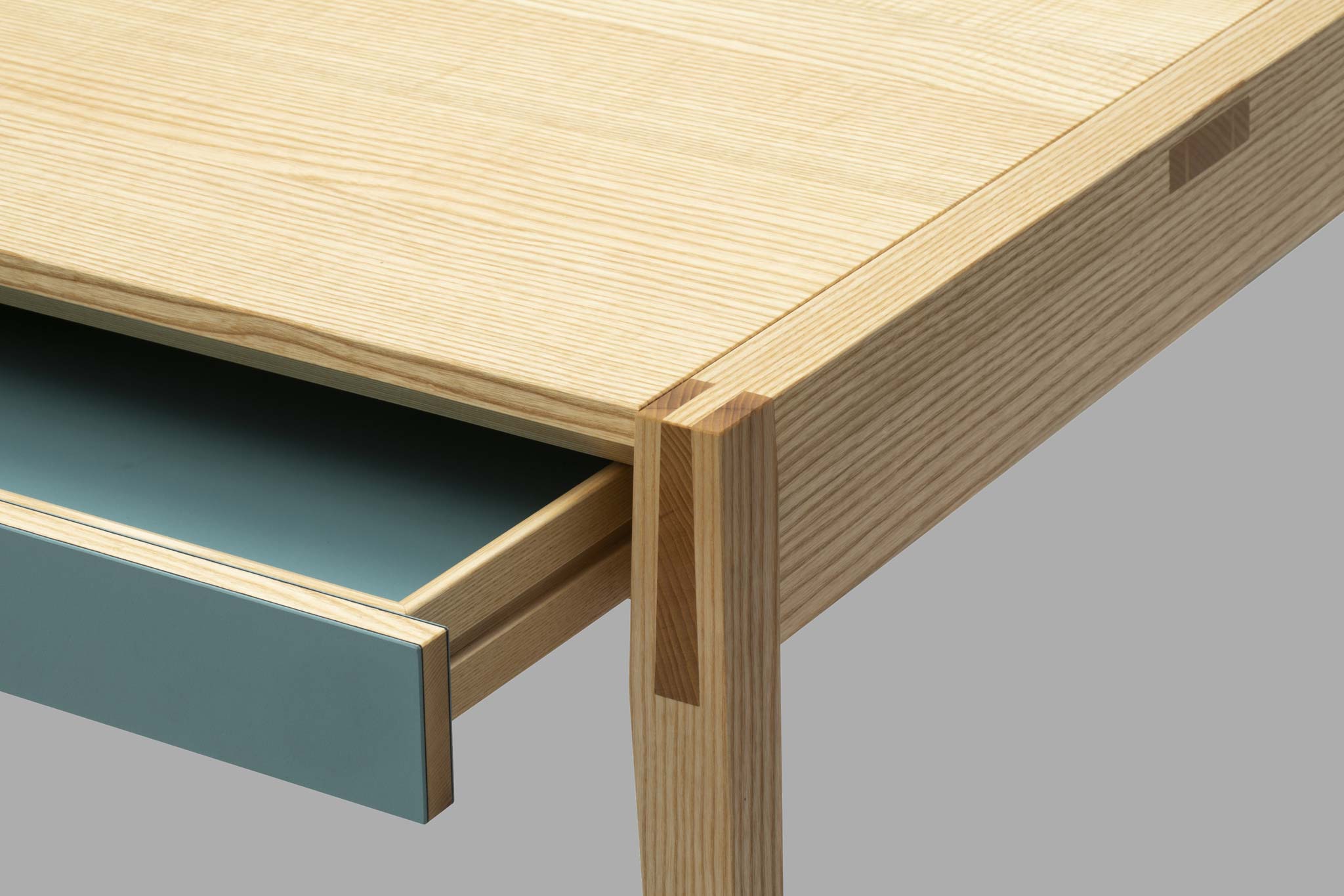 Tischkante mit hochwertiger Holzverbindung und geöffnete Schublade 
