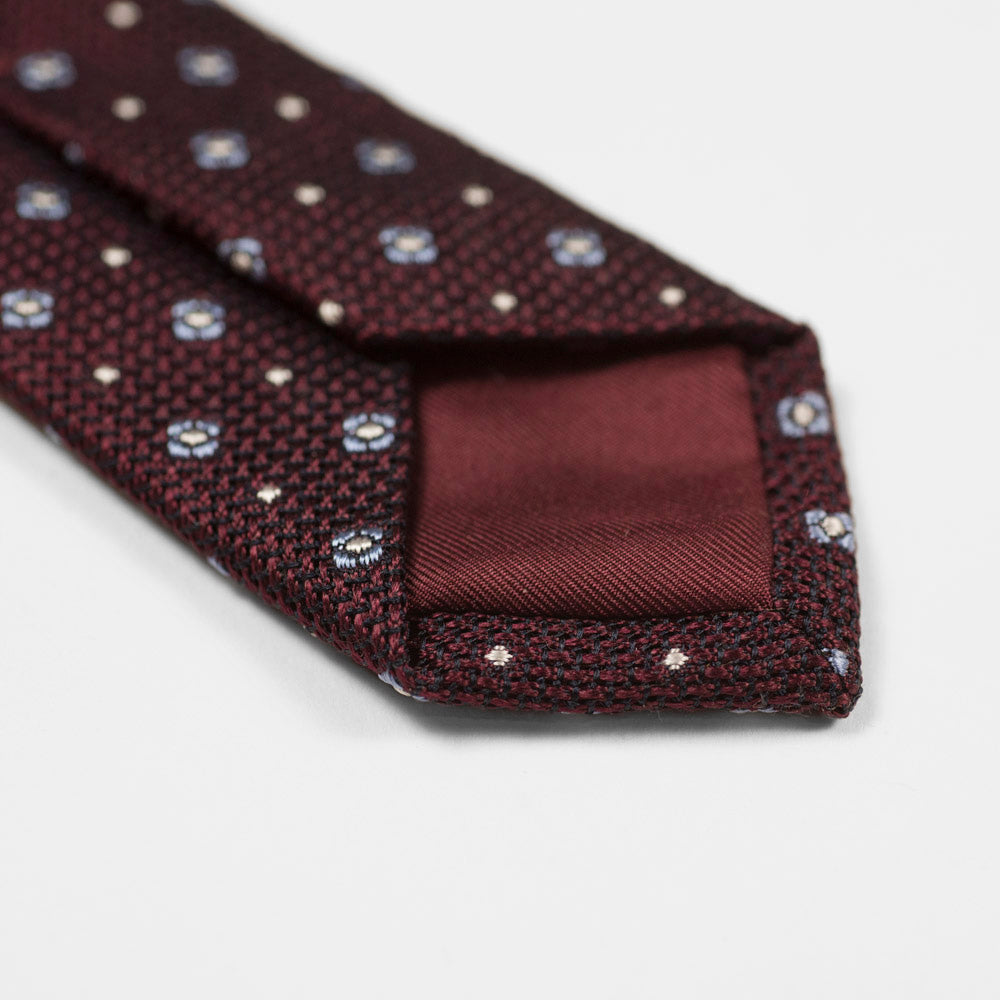 Burgundy woven silk tie, light blue and white neat motifs